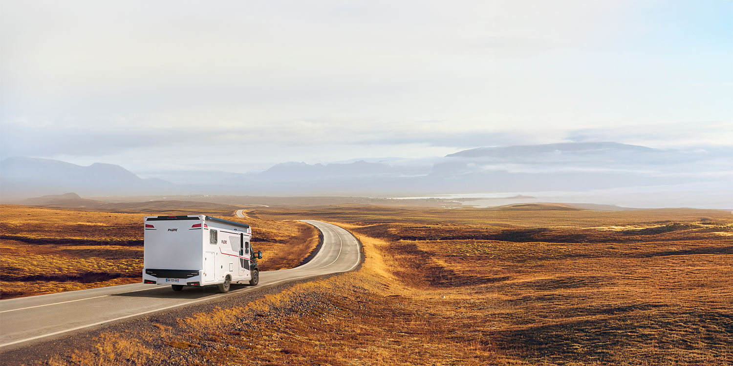 camping-car profilé compact Pilote  roulant sur une route dans des steppes